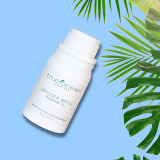 TrueOcean diffuser refill bottle on a blue background with green leaves