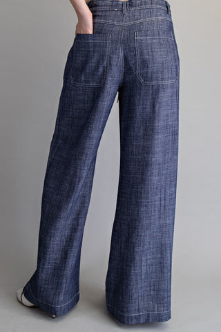 Blue denim wide-leg pants on a gray background