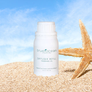 True Ocean diffuser refill bottle on sand with starfish against a blue sky