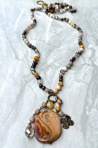 Necklace with a large brown pendant on a textured white surface