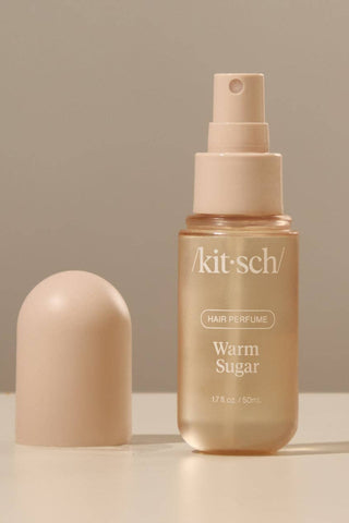 Kitsch hair perfume bottle with cap on a beige background