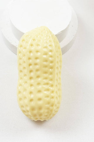 A pale yellow, peanut-shaped textured object with a glossy finish, displayed on a white circular stand against a white background.