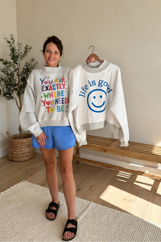 woman holding reversible mockneck sweatshirts