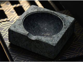 Black stone ashtray on a decorative surface