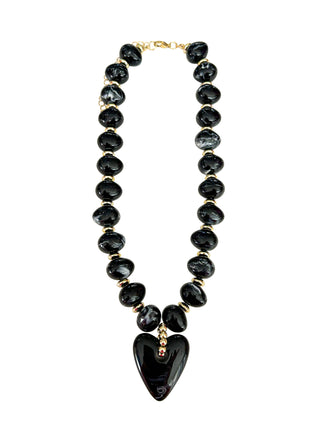 Black beaded necklace with a heart-shaped pendant on a white background