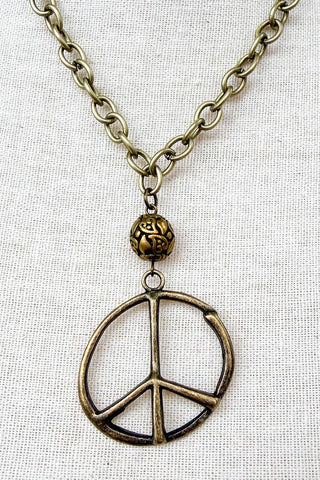 Necklace with a peace symbol pendant on a light fabric background