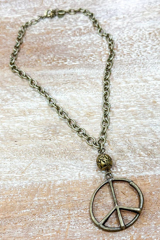 Necklace with peace symbol pendant on a wooden surface