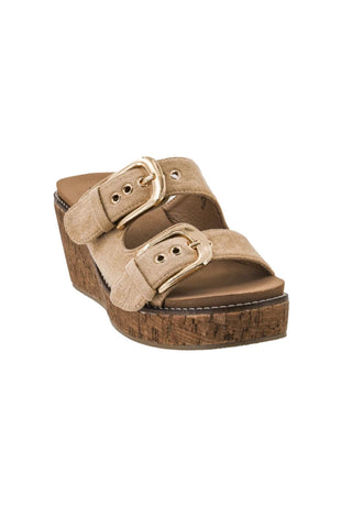 A single women's platform wedge sandal with two wide beige suede-like straps adorned with gold-tone buckles, set against a plain white background.
