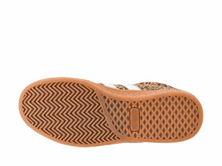 A close-up top-down view of a shoe's sole, showing a tan and brown herringbone tread pattern with a small rectangular logo tab in the center.