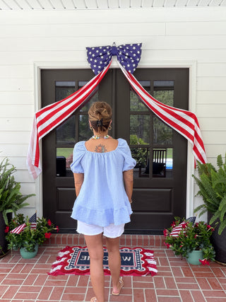 Light blue seersucker babydoll top with puff sleeves and tiered ruffle hem