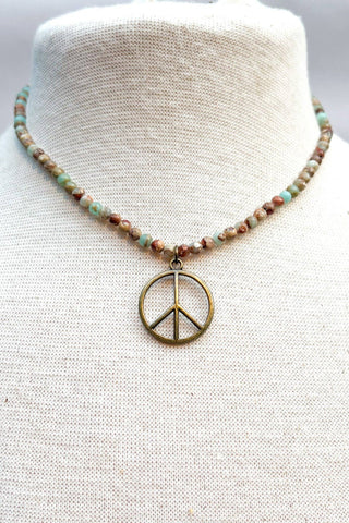 Necklace with a peace symbol pendant on a mannequin bust.