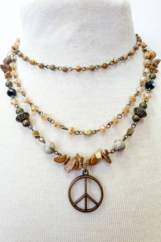 Necklace with peace sign pendant on a mannequin against a white background