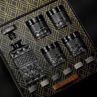Set of black glass decanters with textured design on a decorative tray.