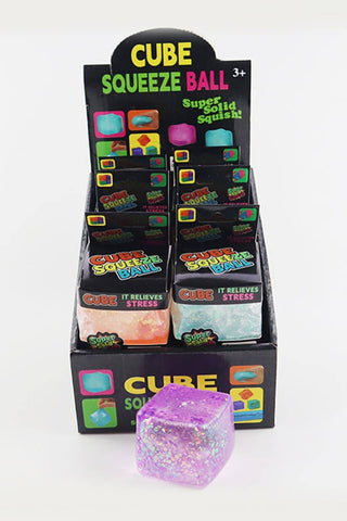 Display of Cube Squeeze Ball packaging with a purple cube in front on a white background