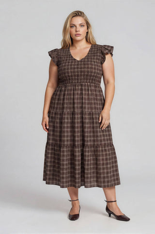 Woman wearing a brown checkered dress on a white background