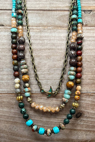 Three beaded necklaces on a wooden surface
