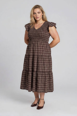 Woman wearing a brown checkered dress on a white background