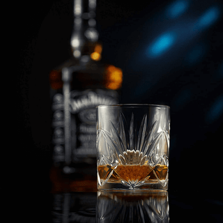 Glass of whiskey with a blurred bottle in the background