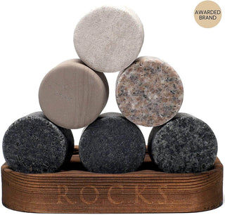 Set of round stone coasters stacked on a wooden tray with 'ROCKS' engraving.