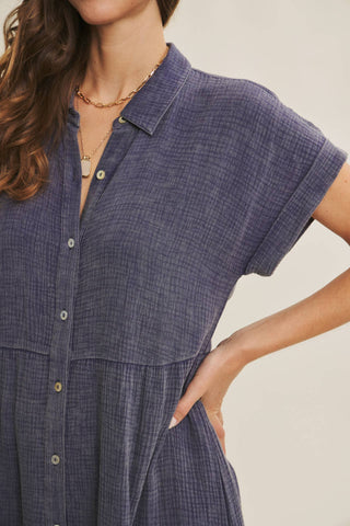 Woman wearing a blue checkered dress with a neutral background