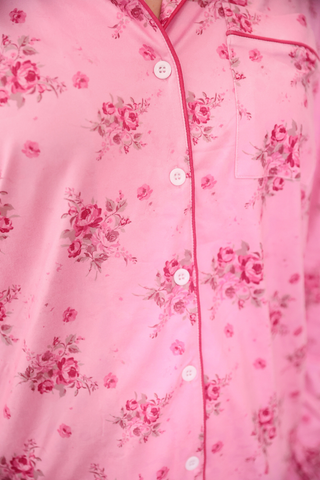 Close-up of a pink floral patterned garment with buttons.