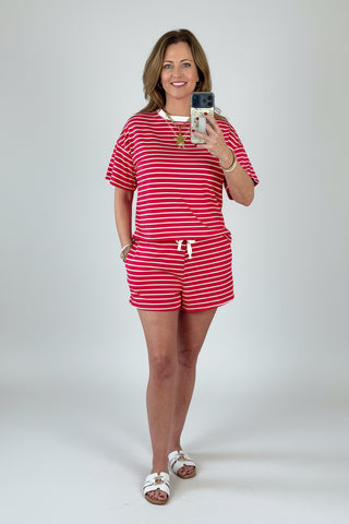 Woman taking a mirror selfie wearing a red and white striped two piece lounge outfit.