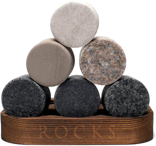 Stack of round stone coasters on a wooden stand with 'ROCK' branding.
