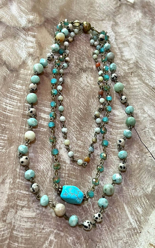 Beaded necklace with turquoise stones on a wooden surface