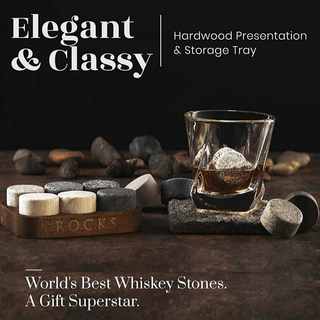 Hardwood presentation and storage tray with whiskey stones and glass on a dark background