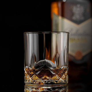 Glass of whiskey with a blurred bottle in the background